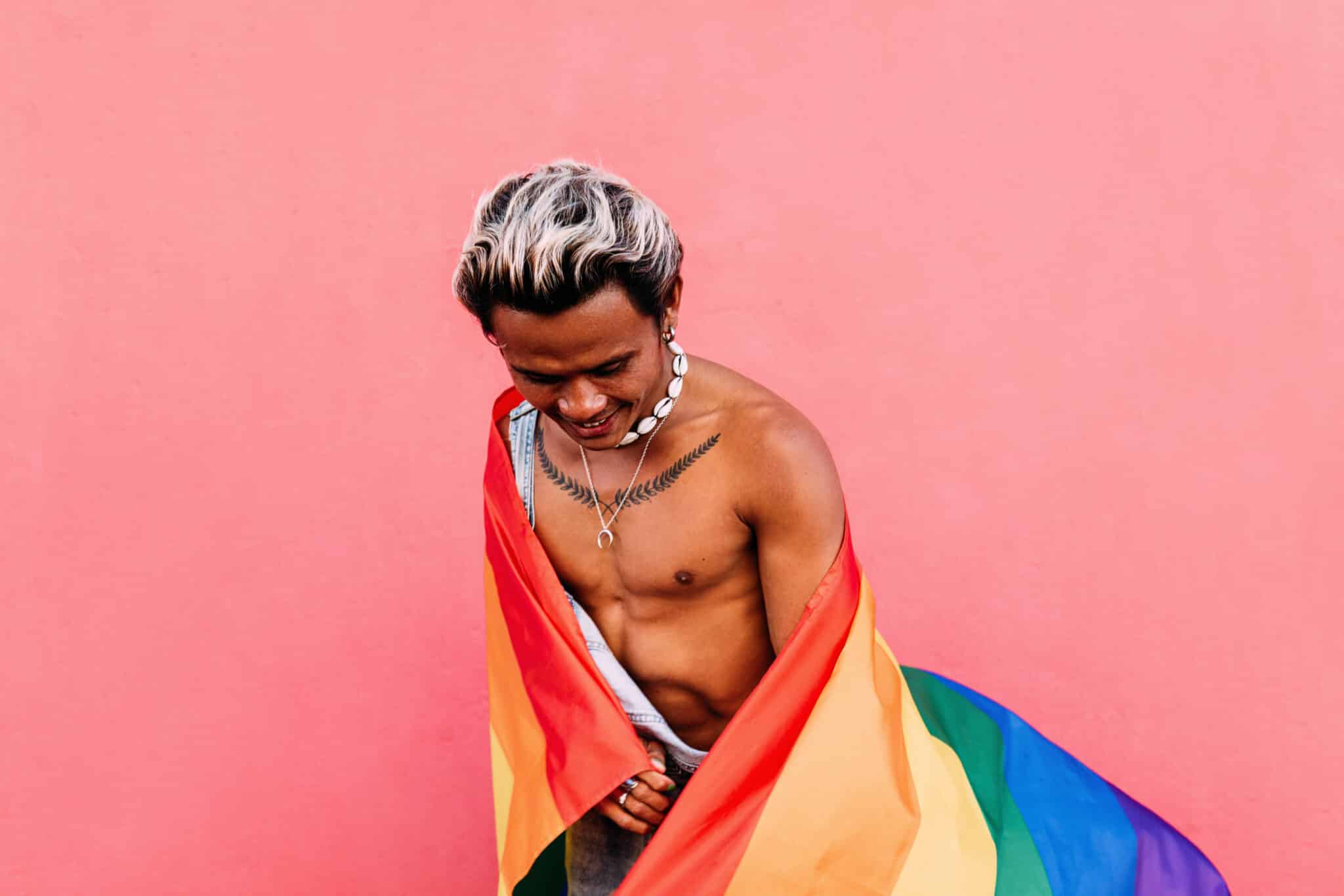 chico sin camiseta con una bandera gay usuario del chat chueca Murcia